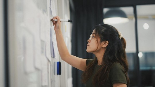 Young woman writing on whiteboard