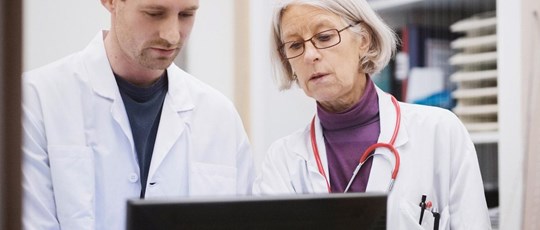 two medical professions looking at a computer screen