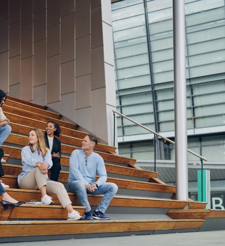 Tietoevry employees meet next to the office building smiling