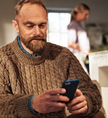 Man using cell phone at home on sofa