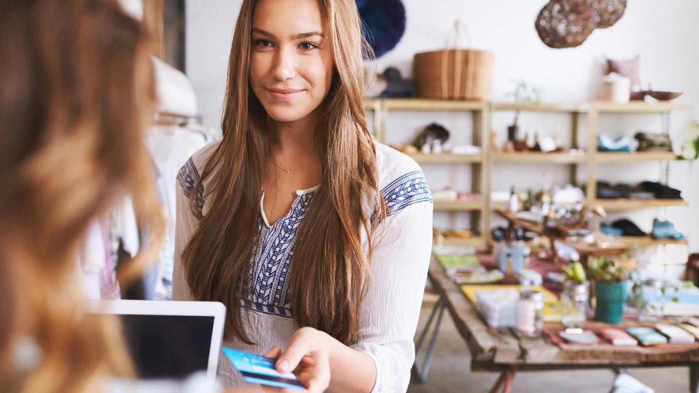Teenage young woman paying with credit card in a boutique
