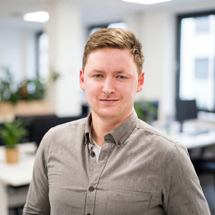 Thomas is our Team Leader in fraud prevention. He is dressed in a beige shirt and stands in our office.