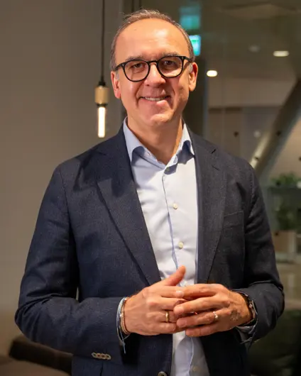 Mario Blazevic looks content as Tieto Banktech has presented the 4 pillars for transformation success. He is wearing a suit.