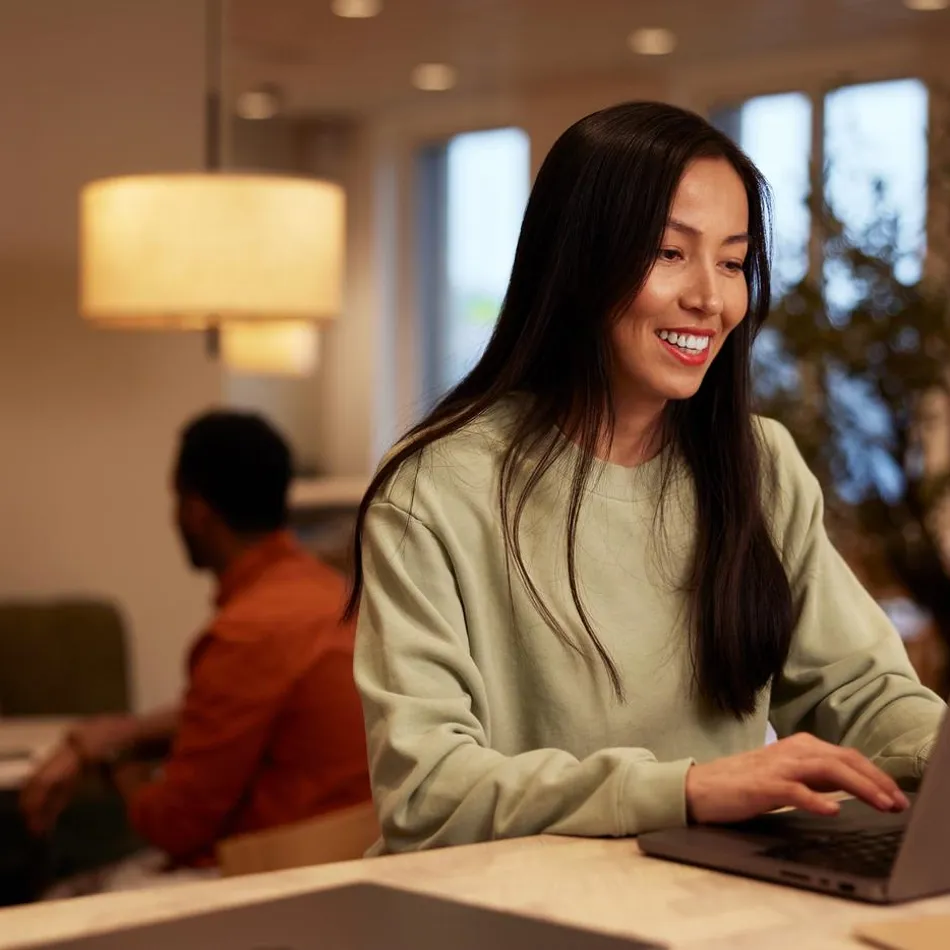 A young woman working on laptop smiling closeup