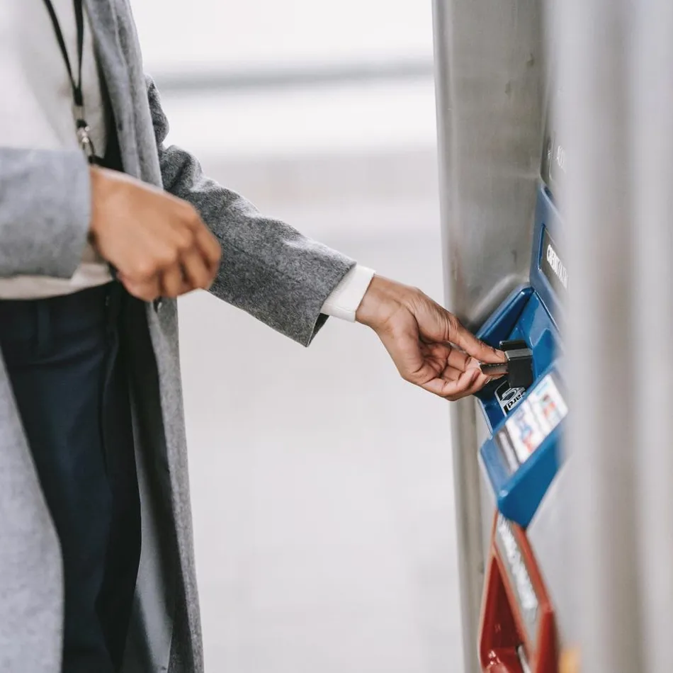 Woman holding a card and using an ATM