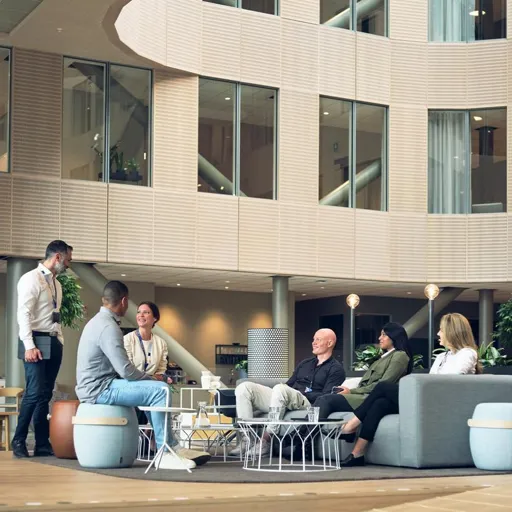 Tietoevry employees meet inside the office building smiling